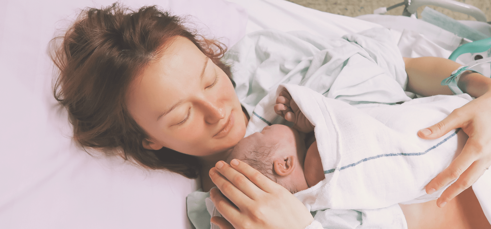 mom holding newborn baby via skin to skin